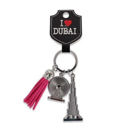 Silver-toned keychain featuring a miniature Burj Khalifa, Ain Dubai wheel, and a hot pink tassel on a black "I Love Dubai" display card.