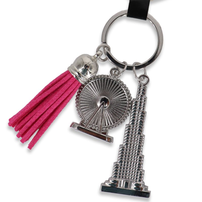 Silver-toned keychain featuring a miniature Burj Khalifa, Ain Dubai wheel, and a hot pink tassel on a black "I Love Dubai" display card..