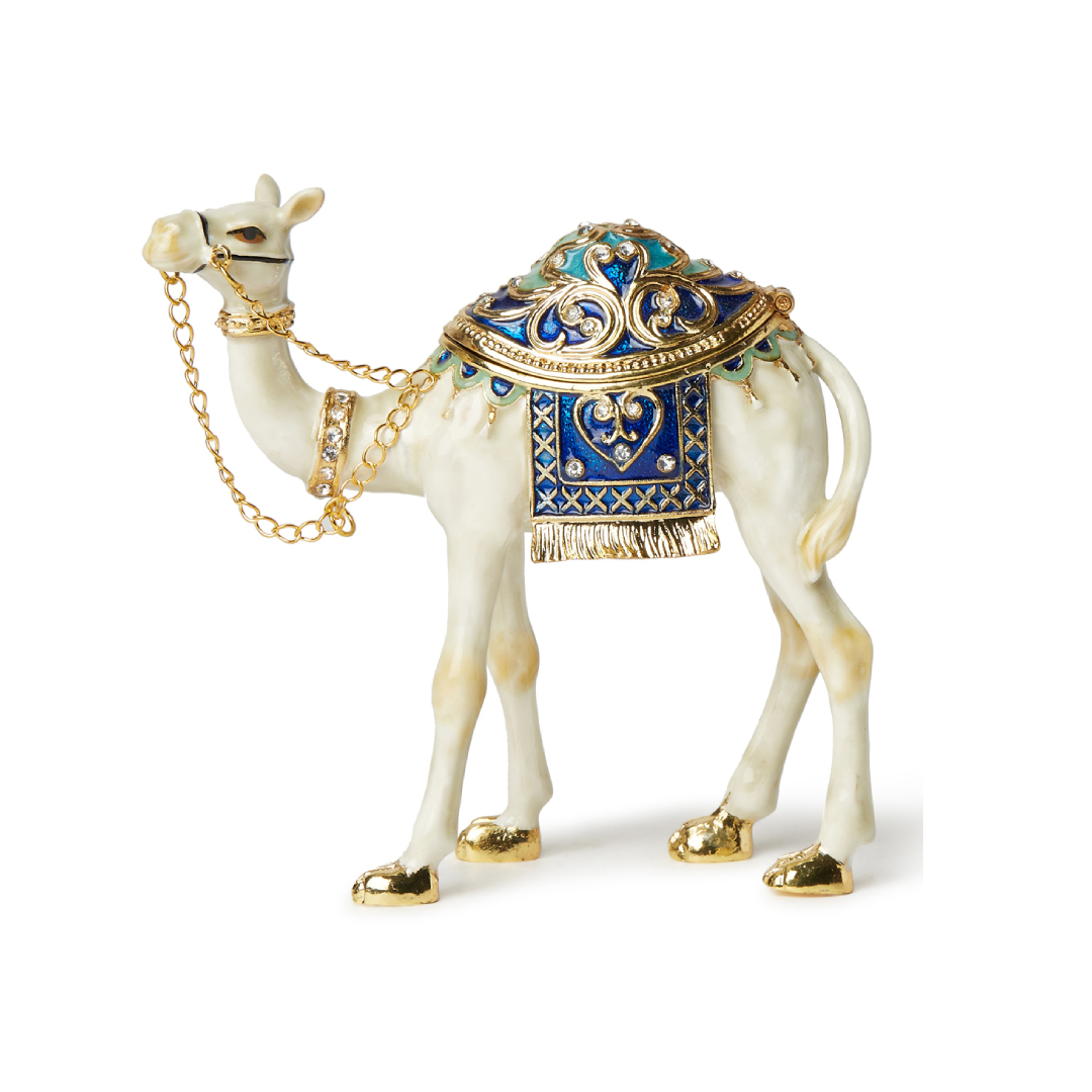 Gold-Tone Arabian Camel Figurine – Ornate Crystal Souvenir Jewelry Box White and gold enameled camel figurine with blue crystal saddle and gold-tone chain bridle, featuring a magnetic opening for jewelry storage.
