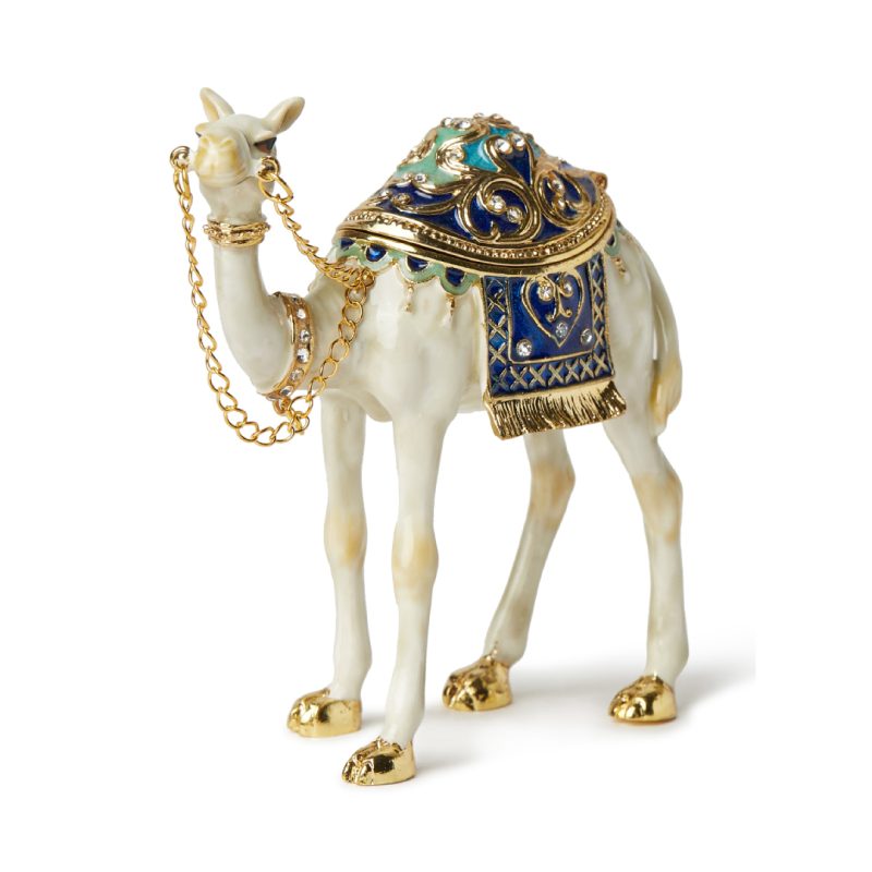 White and gold enameled camel figurine with blue crystal saddle and gold-tone chain bridle, featuring a magnetic opening for jewelry storage.